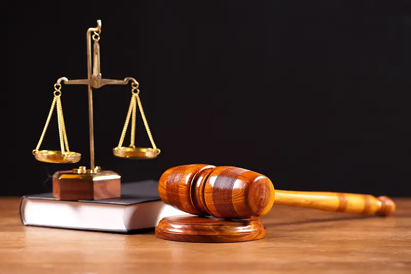 Gavel and book on top of wooden table