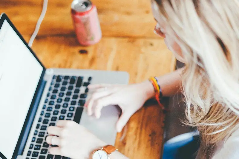 Blonde woman working on her laptop