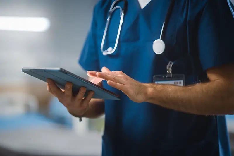 Surgeon Uses Digital Tablet Computer Health Care Vitals Monitoring Computer Machine