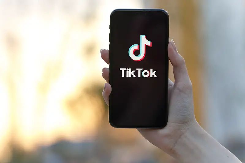 Tik Tok application icon on Apple iPhone X screen close-up.