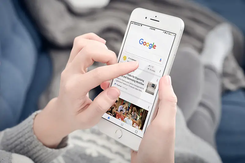 Hand of woman using google on her mobile phone