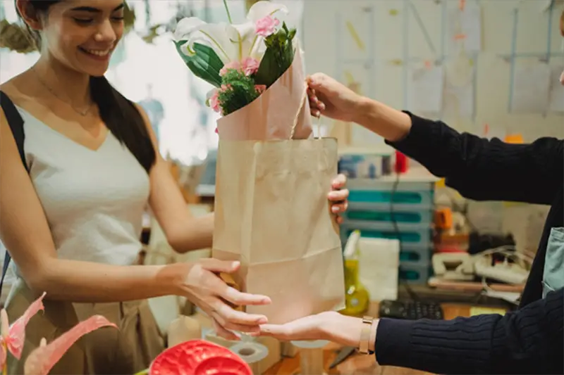 Young woman smiling while buying flowers