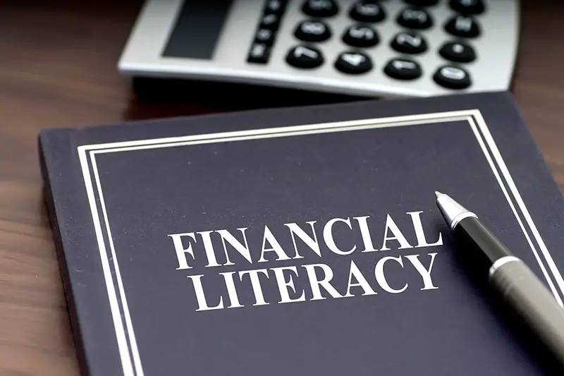 Financial Literacy book with pen and calculator