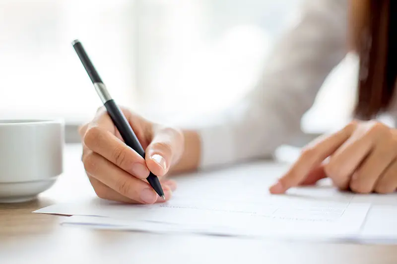 Hand of businesswoman signing on document