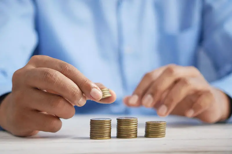 Hand of a person piling a coins