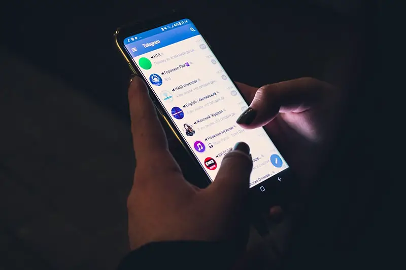 Hand of a woman using mobile phone with telegram apps