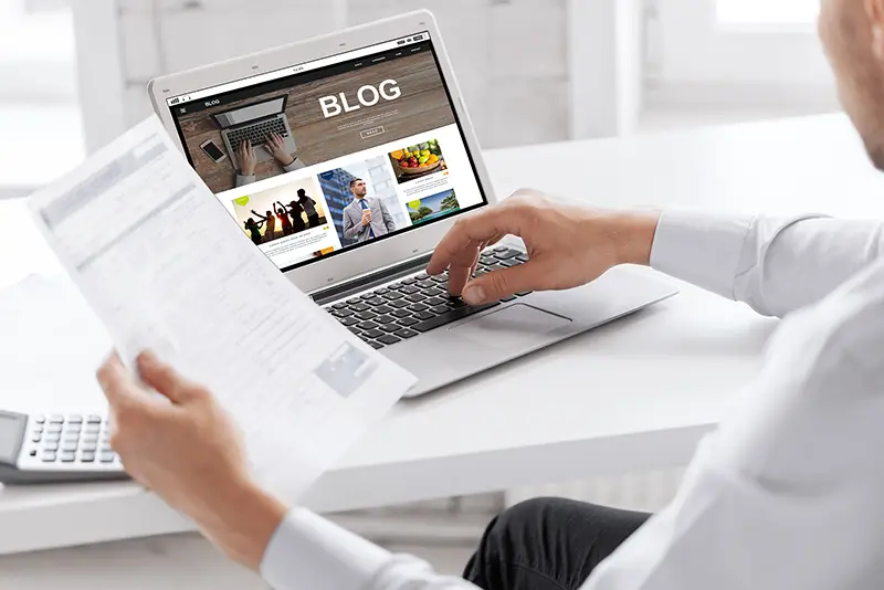 businessman with internet blog page on laptop computer screen working at office