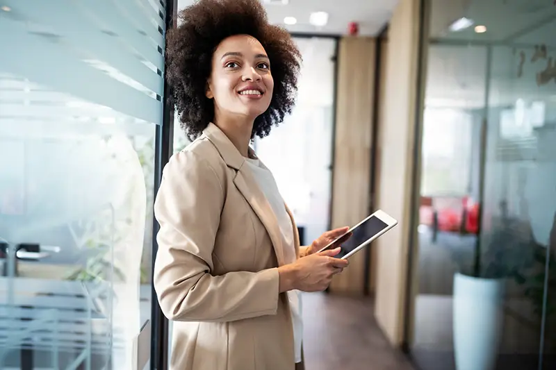 Business woman smiling while holding iPad