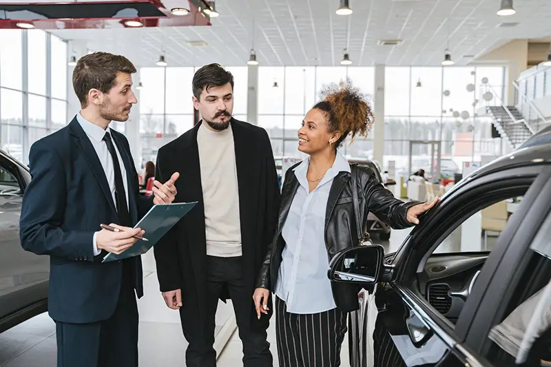 Car sales man talking to a couple client