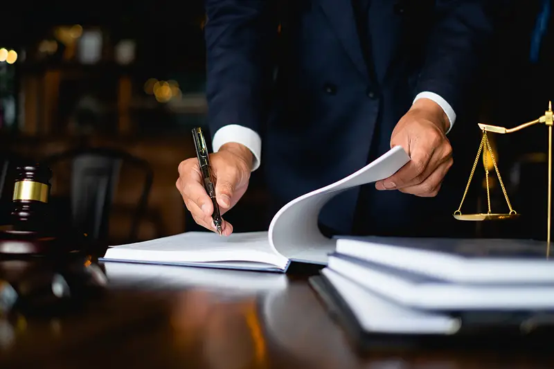 Lawyer signing on a documents on the top of the table