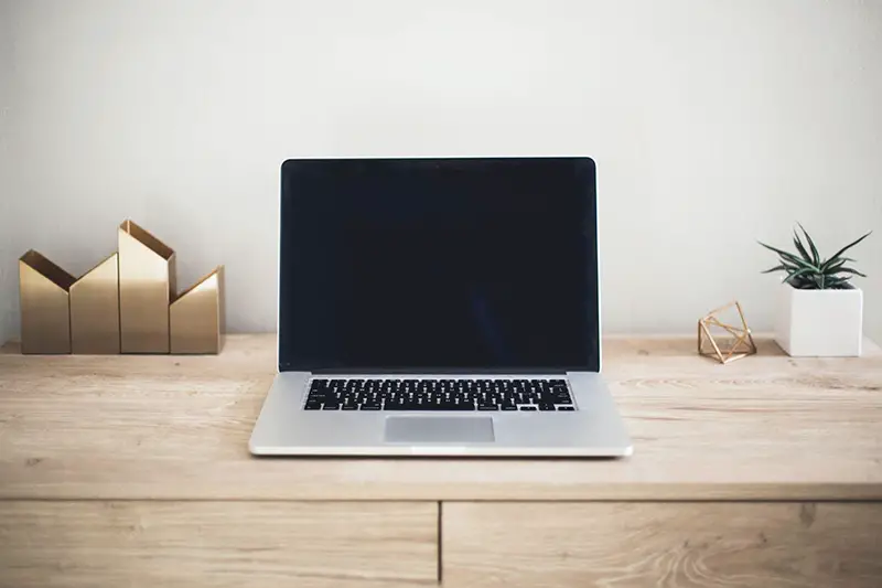 Laptop off screen on top of brown wooden table