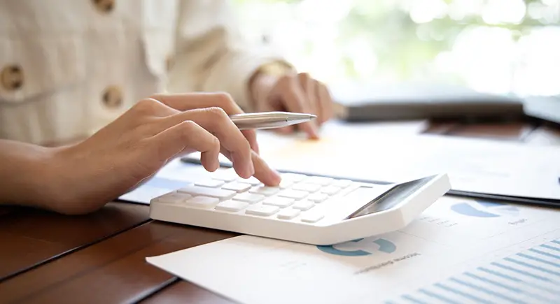 Person using white calculator for accounting tasks