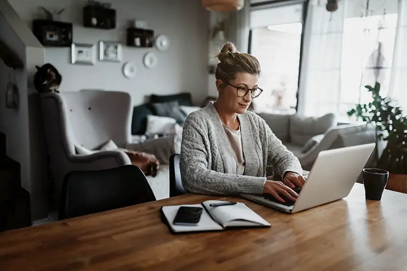 Businesswoman working on laptop computer at home