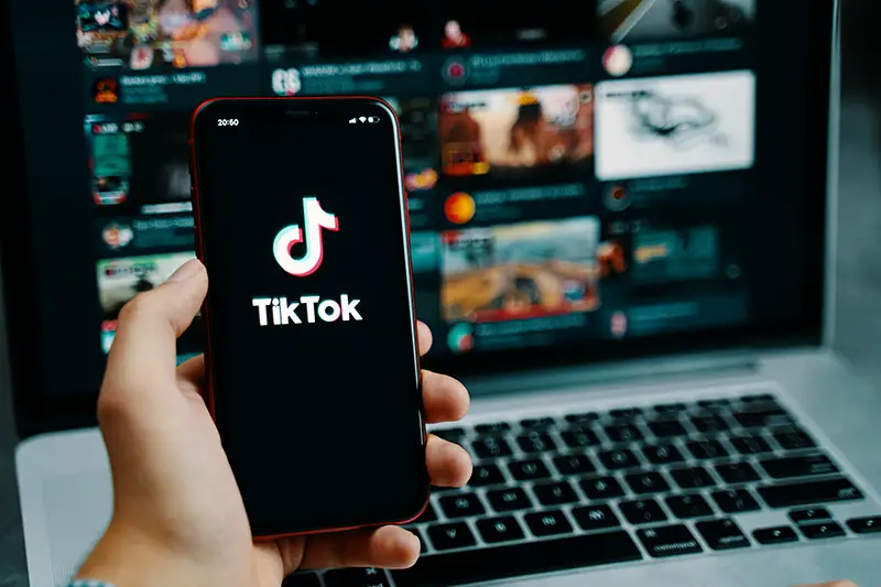 Person holding mobile phone with tiktok logo on the screen