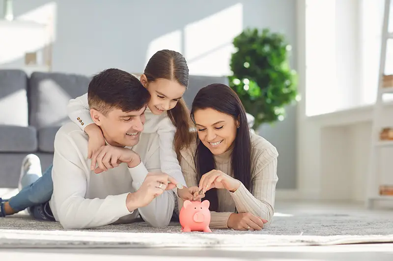 Happy family saves money in a piggy bank 