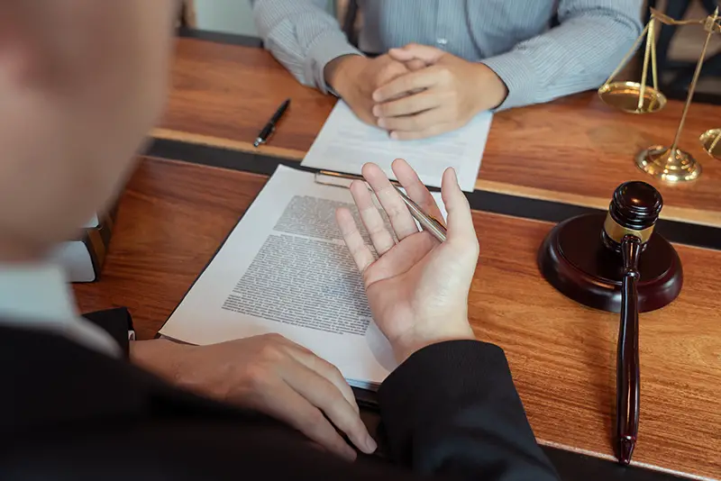 Lawyer talking to his client in front of brown wooden table