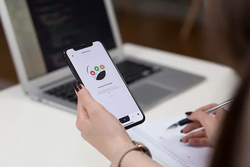 Woman surfing smartphone while working from home