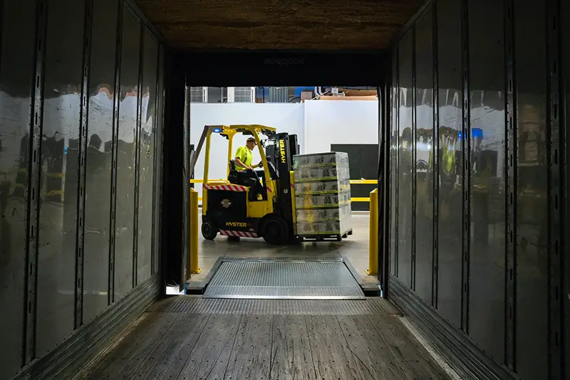 Man carrying box using fork lifter