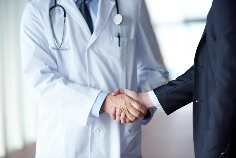 a doctor shaking hands with patient
