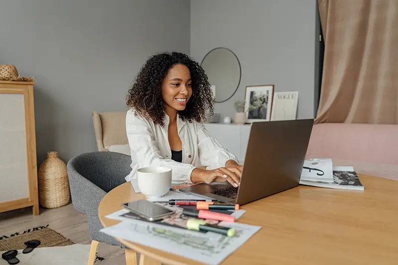 Woman in white long sleeve working from home