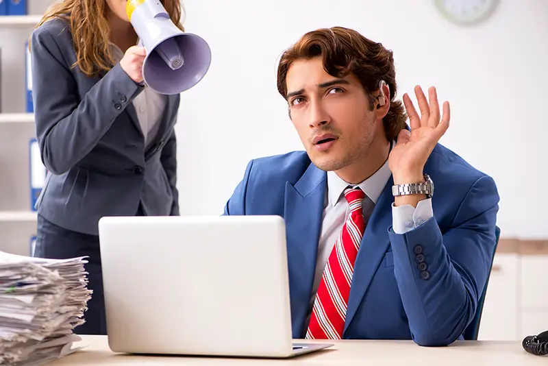 Deaf employee using hearing aid talking to boss