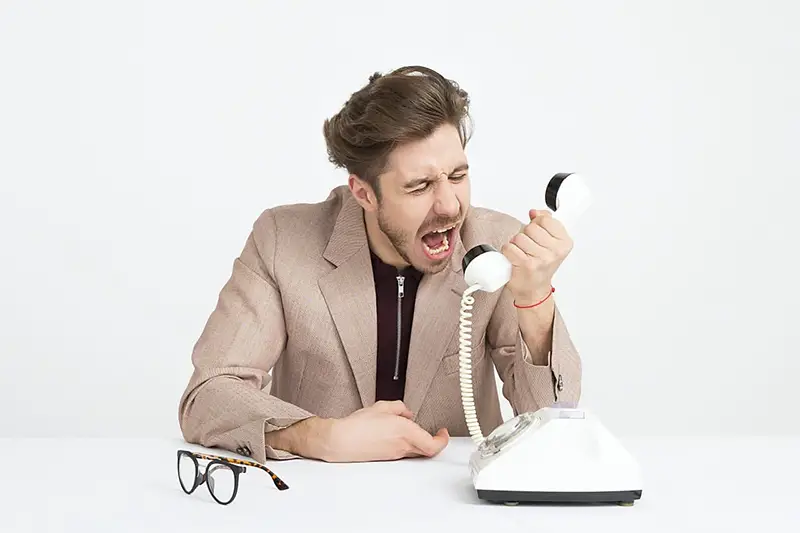 Man yelling towards the telephone handset