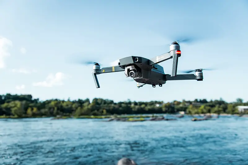 Black DJI Mavi quadcopter near body of water