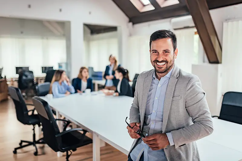 Successful entrepreneur, colleagues working in the background.