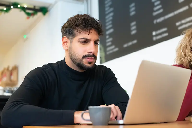 A bearded man using a laptop