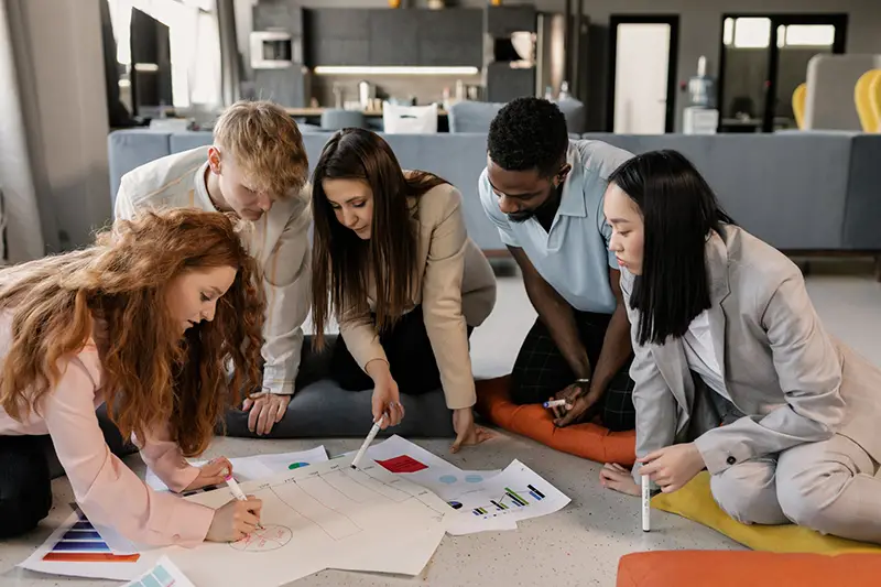 A team writing on a piece of paper on the floor