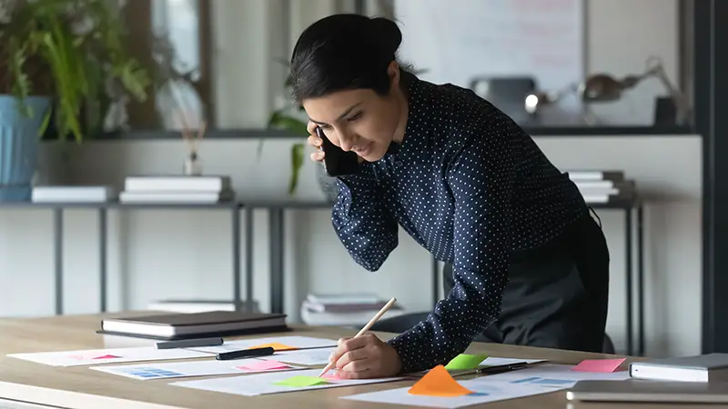 Serious Indian businesswoman talking on cellphone