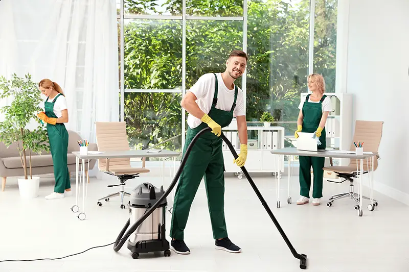 Team of janitors in uniform cleaning office