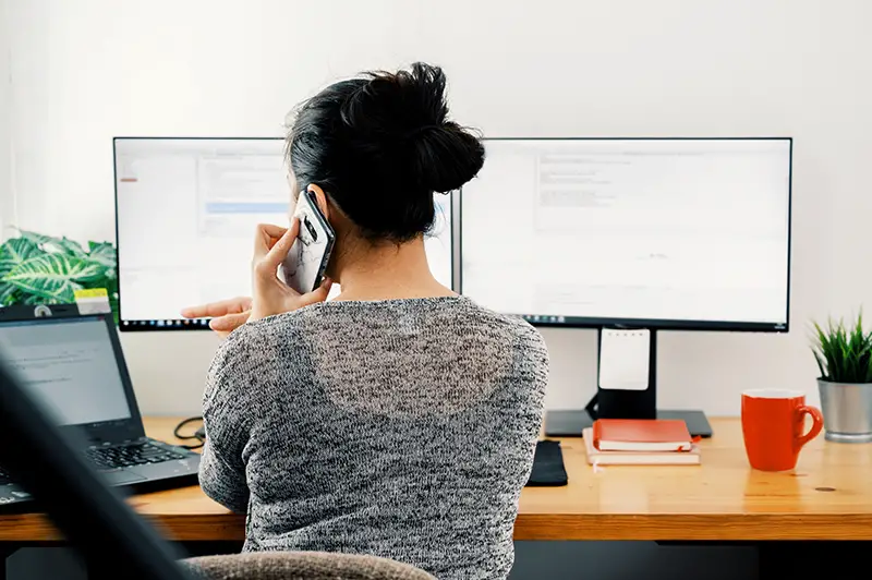 Woman taking a call while sitting in front of computer