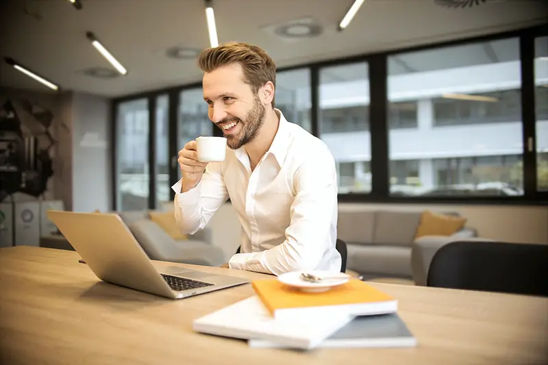 Man working on his desk while drinking coffee