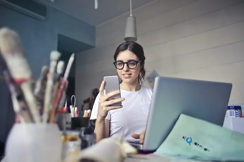 Woman wearing eyeglasses using her smartphone