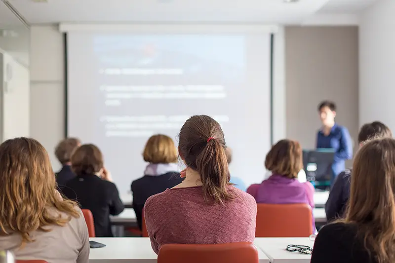 Female speaker giving presentation in lecture hall at university