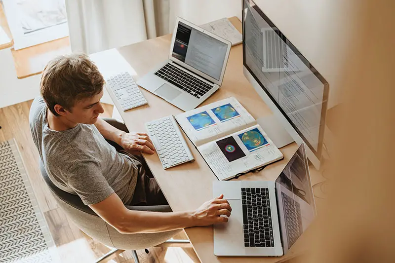 man using three computers