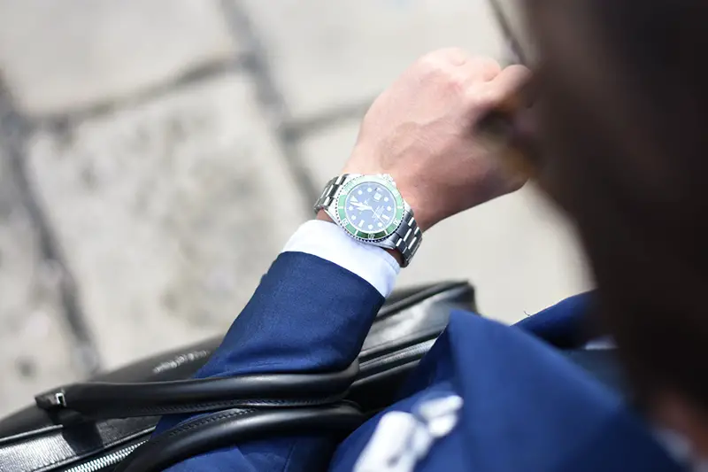 Person looking at silver analog watch