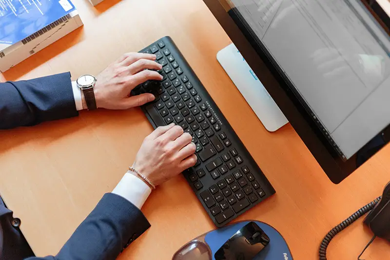 Person typing on computer keyboard