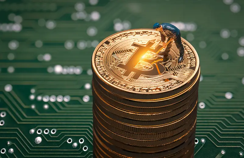 macro miner figurine on shiny bitcoin stack