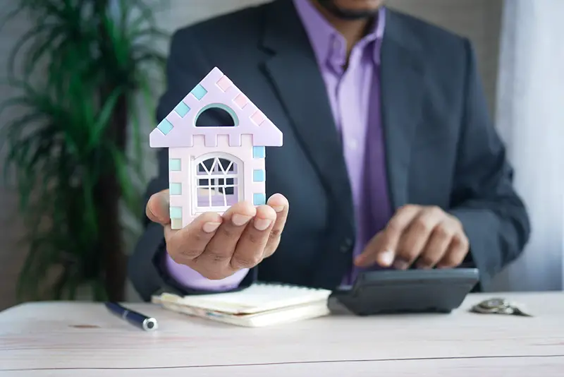 man holding house miniature in hand