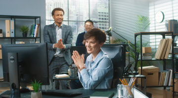 Mixed-race co-workers clapping hands behind