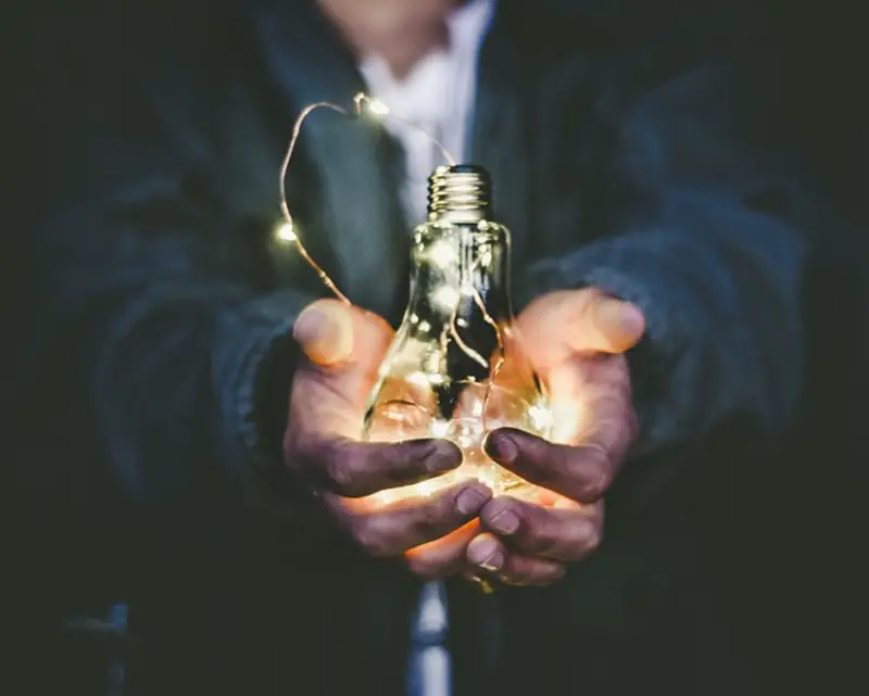 Businessman holding light bulb on his hands