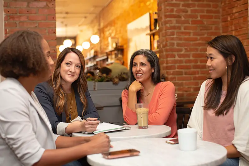 Four women talking inside the cafeteria