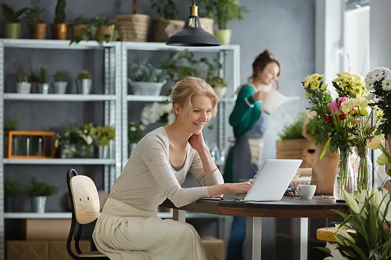 Two smiling florists working in a flower shop