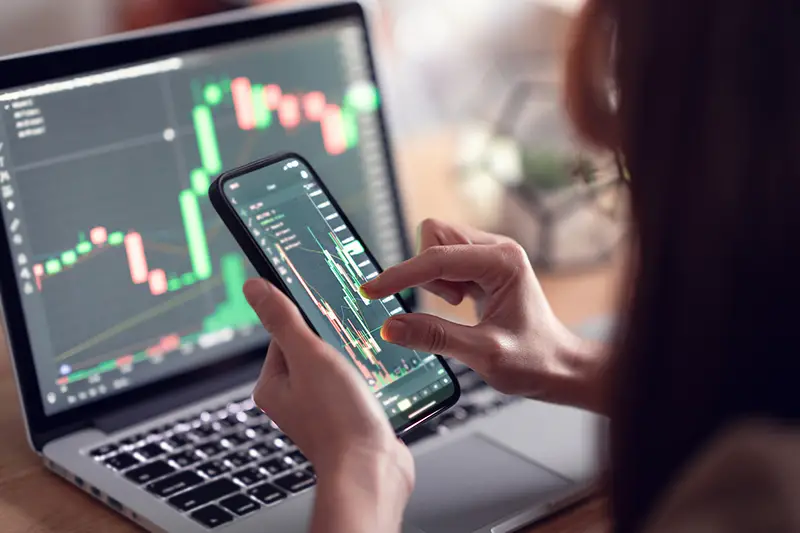 Woman checking Bitcoin price chart on digital exchange on smartphone