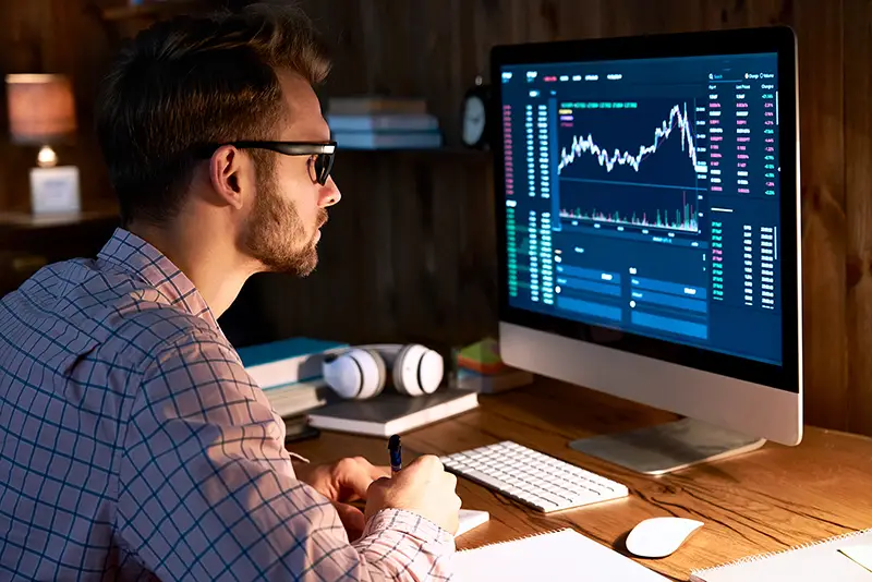 Business man trader analyst looking at computer monitor