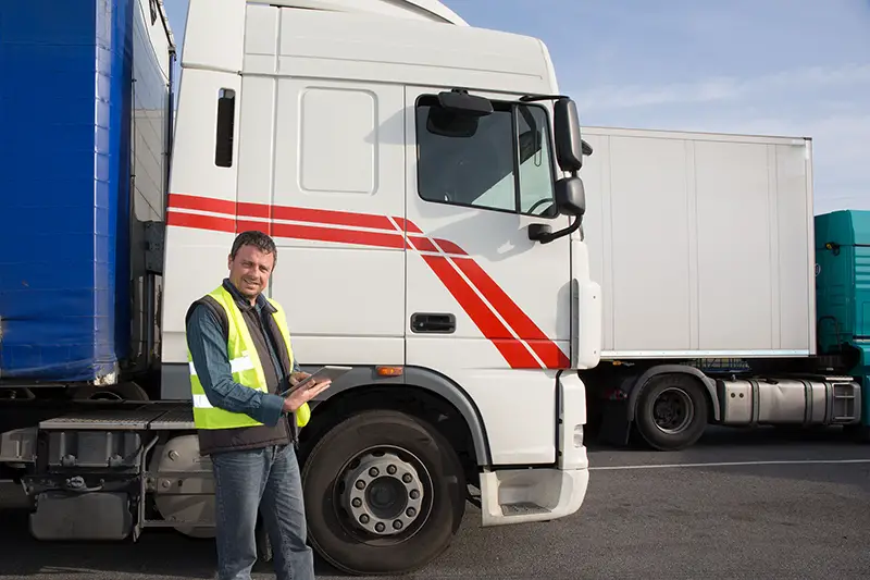 Forwarder in drivers cap of truck and trailer