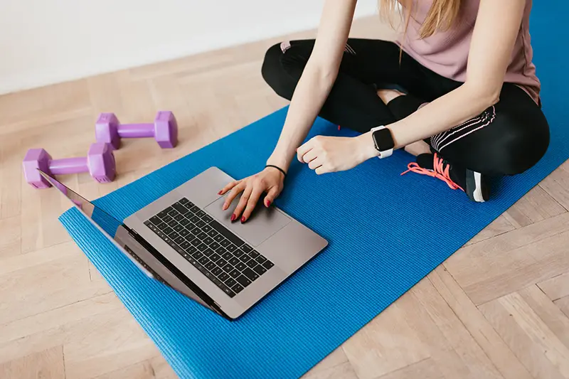 Woman using laptop on mat