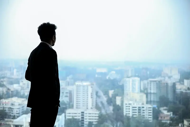 Man in black suit standing on the top of the building